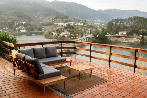 a balcony with two couches and a table and a view at Caniçada House - Gerês in Vieira do Minho