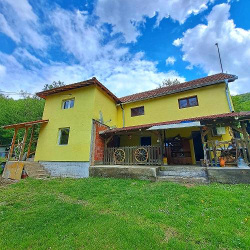 a yellow house on top of a green field at STD "Vila Bor" Stara planina in Crni Vrh