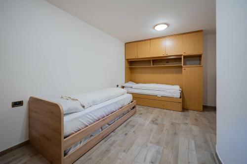 マッツィンにあるCasa Liefのベッド2台 木製キャビネット付きの部屋
