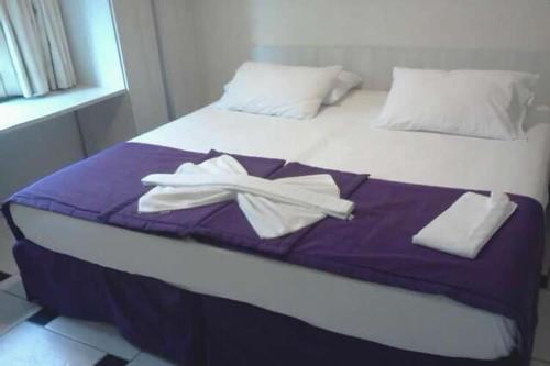 a bed with two white towels on top of it at Hotel Arrecife dos Corais in Cabo de Santo Agostinho