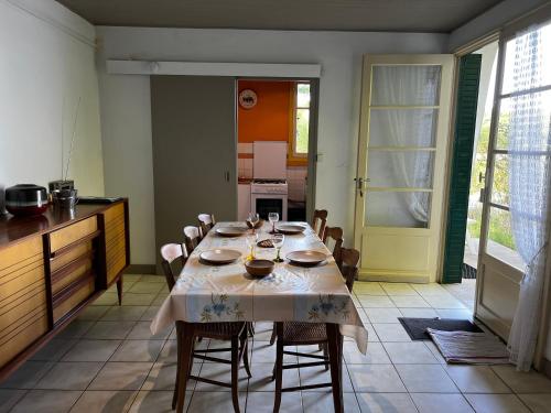 une salle à manger avec une table et des chaises et une cuisine dans l'établissement Chalet au bord de l'étang 4 pers, à Les Boulmiers