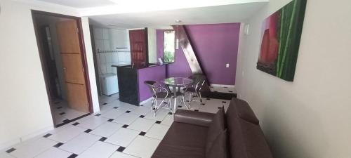 a kitchen with purple walls and a table and chairs at Hotel Arrecife dos Corais in Cabo de Santo Agostinho