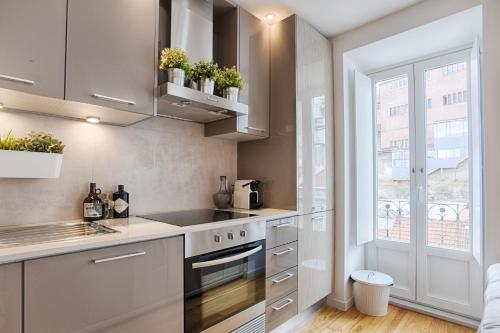 a kitchen with stainless steel appliances and a window at BmyGuest - 28 Tram Central Apartment in Lisbon