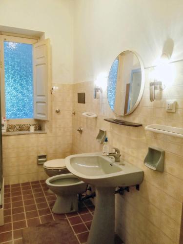 a bathroom with a sink and a toilet and a mirror at 2 bedrooms apartement with enclosed garden at Vita in Vita