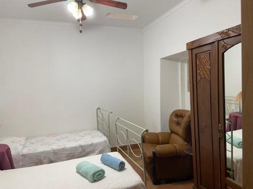 a room with a chair and a bed and a mirror at A casa da Maria in Luz de Tavira