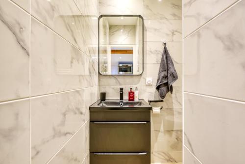 une salle de bain avec un lavabo et un miroir dans l'établissement NEW / Belle et Rebelle avec jacuzzi, à Lyon