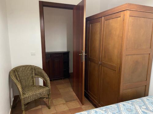a bedroom with a closet and a chair next to a door at A casa da Maria in Luz de Tavira