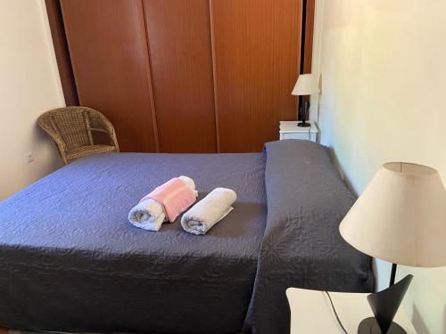 a bed with two pillows on it in a room at A casa da Maria in Luz de Tavira