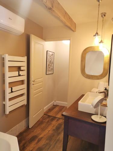 une salle de bain avec un lavabo et un miroir dans l'établissement Mas provençal cosy avec piscine dans le Sud !, à Courthézon