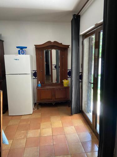 a kitchen with a white refrigerator and a window at A casa da Maria in Luz de Tavira