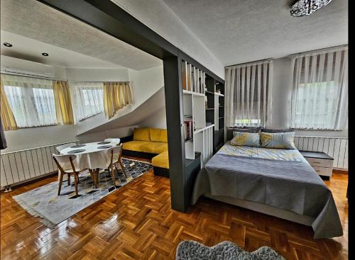 een slaapkamer met een bed en een tafel en stoelen bij Aventurin Superior Apartments in Bihać