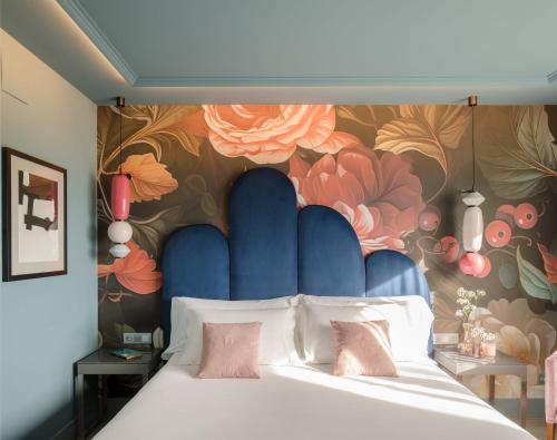 a bedroom with a large bed with a floral wall at Hotel Antik San Sebastián in San Sebastián