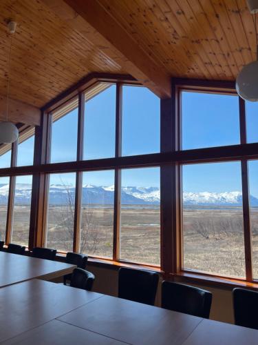 a conference room with a view of mountains from windows at Vökuholt Lodge in Laxamýri