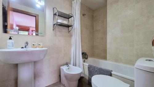 a bathroom with a sink and a toilet and a bath tub at Aprtamento El Llagu Zolitru in Llanes