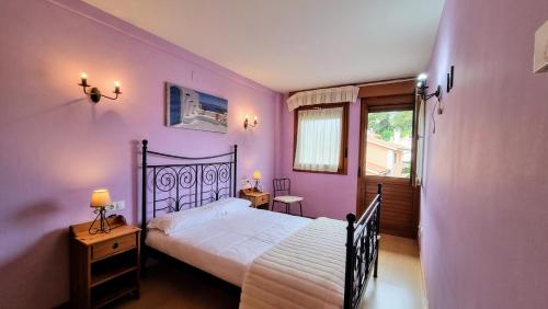 a bedroom with purple walls and a bed and a window at Aprtamento El Llagu Zolitru in Llanes