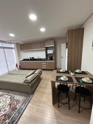 ein Wohnzimmer mit einem Bett, einem Tisch und Stühlen in der Unterkunft Kitnet 5 in Rio Negrinho