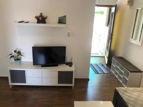 a living room with a flat screen tv on a cabinet at Apartman Tatjana in Rab