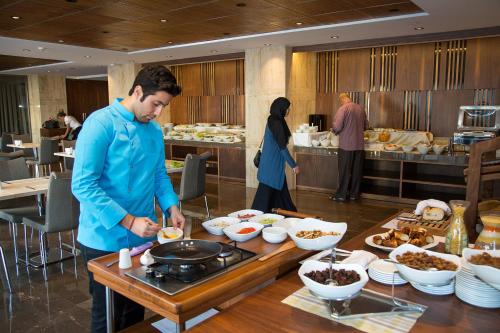 a man preparing food at a buffet in a restaurant at Fesa Business Hotel in Gebze