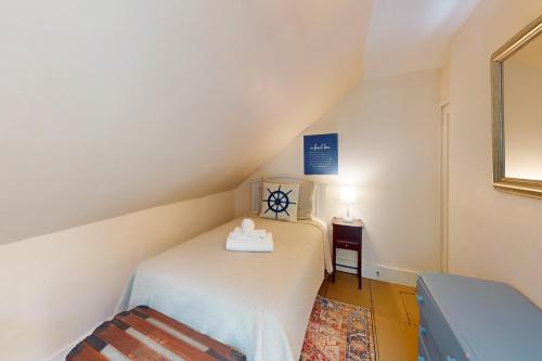 a small bedroom with a bed and a table at Gray Gables in Orleans