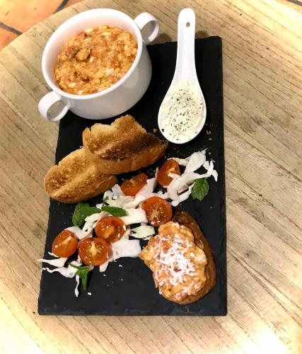 a black plate with food on a table at Morpheus Rooms in Kinion