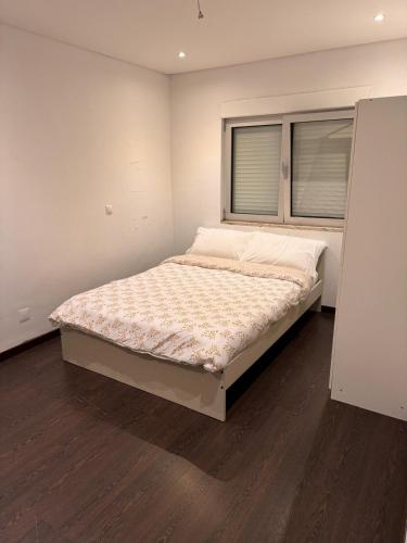 a large bed in a room with a window at Odivelas Inn in Odivelas