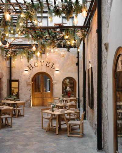 a restaurant with wooden tables and chairs and lights at Casa 63 Hotel Boutique & Spa in San Miguel de Allende