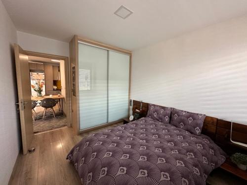 a bedroom with a purple bed and a table at URBAN APARTMENT in Amaliás