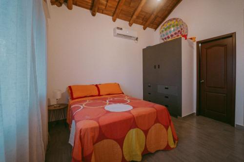 a bedroom with a bed with an orange blanket at Casa vacacional Olon in Olón
