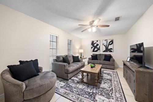 ein Wohnzimmer mit zwei Sofas und einem Flachbildfernseher in der Unterkunft Seabrook Sanctuary Cozy 3BR Home Perfect for Families Privacy & Comfort Galore in Seabrook