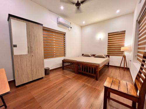1 dormitorio con 1 cama y suelo de madera en Chittattinkara Ayurvilla Traditional wellness Retreat, en Trivandrum