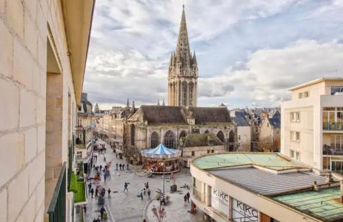une ville avec une tour de l'horloge et une église dans l'établissement Charmant deux pièces Caen centre, à Caen