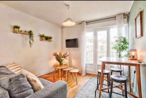 un salon avec un canapé et une table dans l'établissement Charmant deux pièces Caen centre, à Caen