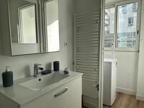 une salle de bain blanche avec un lavabo et un miroir dans l'établissement Esprit méditerranéen, à Toulon