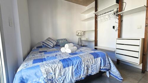 Un dormitorio con una cama azul y blanca con toallas. en Encantador Depto en Cañitas Palermo en Buenos Aires