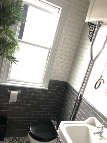 a bathroom with a black toilet and a sink at Victorian Guest House 200m from the Seafront in West Kirby