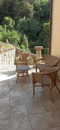 two wicker chairs and a table on a patio at Borgo Ingurtosu in Ingurtosu