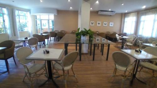 a dining room with tables and chairs and windows at CATANGE HOTEL in Charata