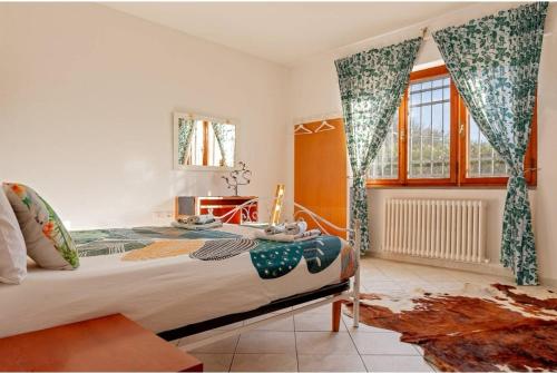 una camera con letto e finestra con tende di LE 7 CALLE a Pisa