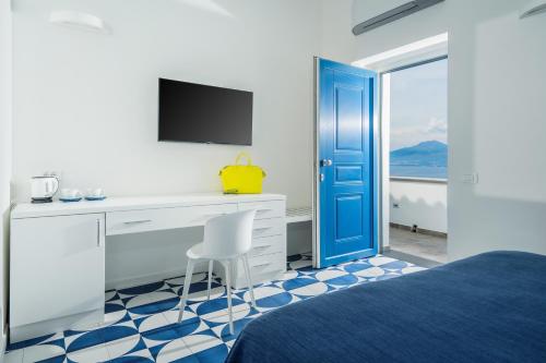 1 dormitorio con escritorio y puerta azul en Villa Azzurra, en Vico Equense