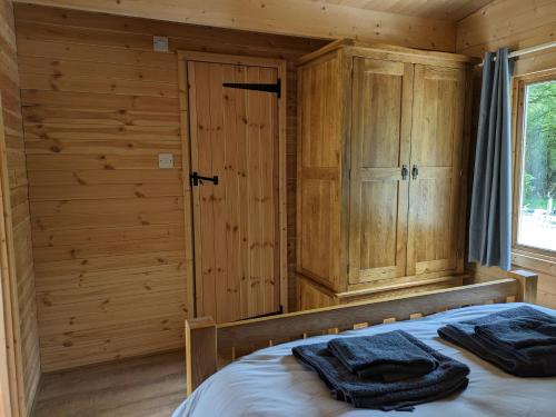 a log cabin bedroom with a bed and wooden walls at Cosy Cabin in Stock