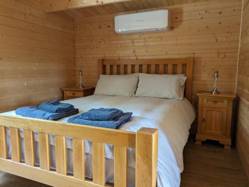 1 dormitorio con 1 cama en una cabaña de madera en The Cabins en Stock