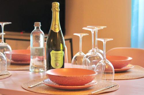 a table with a bottle of wine and wine glasses at The Painter's Nest with Private Lake Garden in Cima
