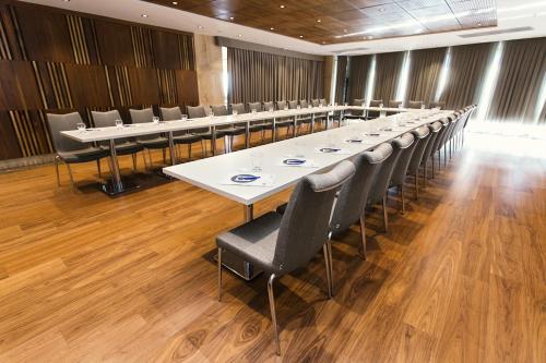 a long tables and chairs in a room with wooden floors at Fesa Business Hotel in Gebze