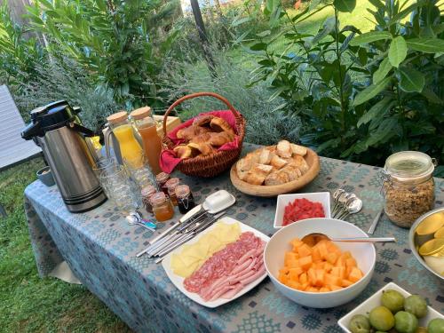 una mesa con queso y otros alimentos. en Au Pré Fleuri Eco Glamping, en Le Lindois