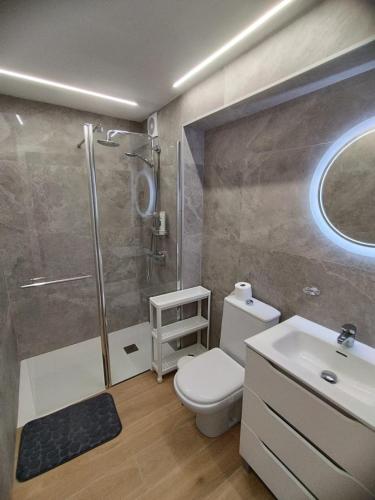 a bathroom with a shower and a toilet and a sink at Beach Home San Agustín in San Bartolomé
