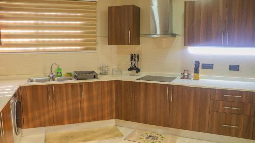 eine Küche mit Holzschränken und einem Waschbecken in der Unterkunft Palm Court in Accra