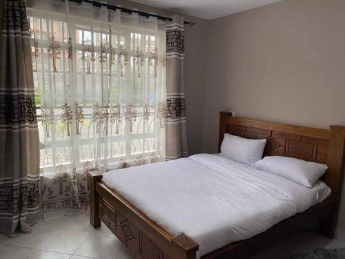 a bedroom with a bed and a large window at Riiri Heights Ong'ata Rongai in Ongata Rongai 