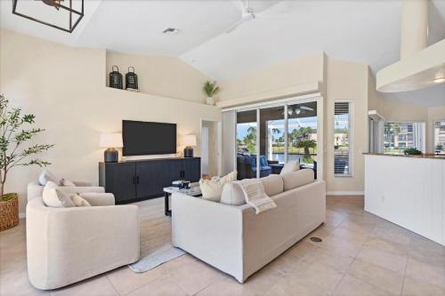 a living room with two white couches and a tv at 120 Great Isaac in Punta Gorda