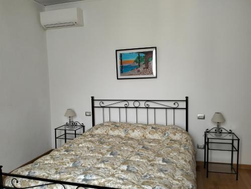 um quarto com uma cama e duas mesas de cabeceira em Casa degli Ulivi em Salò