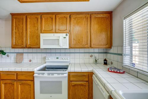 a kitchen with wooden cabinets and a white stove top oven at Fun-Filled Backyard Bakersfield Family Haven! in Bakersfield